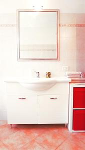 uma casa de banho com um lavatório branco e um espelho. em L' appartamento sul Naviglio em Milão