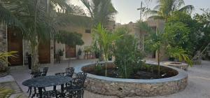 a courtyard with a table and chairs and palm trees at Departamentos MG in Valladolid