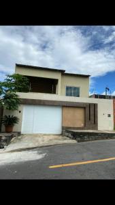 uma casa com duas portas de garagem numa rua em Viçosa Flat em Viçosa do Ceará