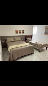 - une chambre avec un grand lit et une table dans l'établissement Viçosa Flat, à Viçosa do Ceará