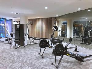 a gym with treadmills and machines in a room at Brilliant Victoria Harbour Waterfront in Melbourne