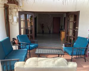 a living room with blue chairs and a table at Ruim gasten verblijf dicht bij zee in Savaneta