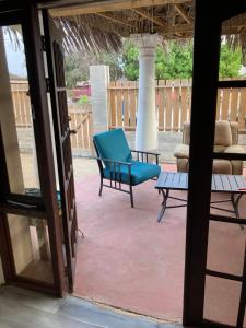 patio z niebieskim krzesłem i kanapą w obiekcie Ruim gasten verblijf dicht bij zee w mieście Savaneta
