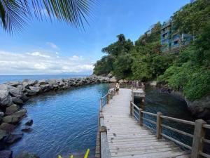 a wooden boardwalk leading to a body of water at Porto Real Resorts - Apartamento com Vista in Mangaratiba