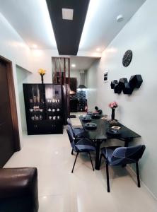 a dining room with a black table and chairs at SNOW Transient - Near Clark Airport, Dinosaurs Island, Aqua Planet in Mabalacat