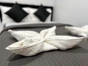 een witte handdoek op een bed met twee kussens bij Pet-friendly by Isla Stays in Cebu City