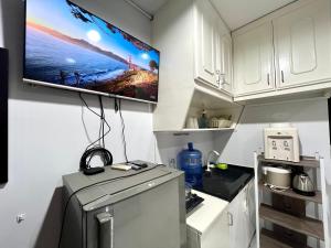 een keuken met een koelkast en een tv aan de muur bij Pet-friendly by Isla Stays in Cebu City