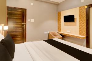 a hotel room with a bed and a television at OYO The Opulent Hotels And Resorts in Bhubaneshwar