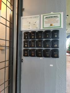 a calculator on a wall next to a door at Sunset Homestay - Backpacker Hostel Self Checkin in Kuching