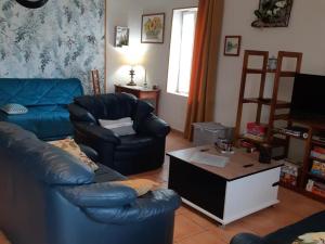 a living room with a leather couch and a coffee table at Évasion à Luzillé : Havre de Paix avec Jardin Privatif, proche Chenonceau et Beauval - FR-1-381-303 in Luzillé