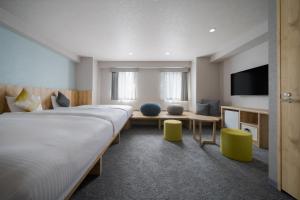 a hotel room with a large bed and a tv at Premier Hotel-CABIN-Sapporo in Sapporo