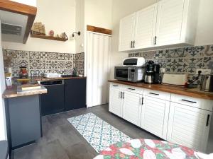 uma cozinha com armários brancos e um micro-ondas em Appartement Banyuls-sur-Mer, 3 pièces, 4 personnes - FR-1-309-380 em Banyuls-sur-Mer