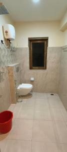 een badkamer met een toilet en een tv aan de muur bij Gonay Manor in Leh