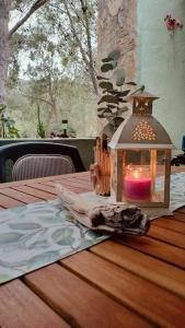 una lanterna con una candela su un tavolo di legno di DomuNosta Pinus Village a Santa Margherita di Pula