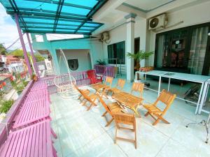 a patio with wooden tables and chairs on a house at Thanh Sơn Homestay in Cao Bằng