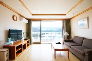 un soggiorno con divano e una grande finestra di Wellihilli Park Resort a Hoengsong