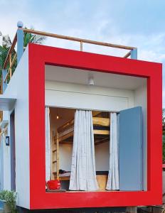a red and white house with a window at Tiny House's Seafront Room in Camotes Island in Esperanza