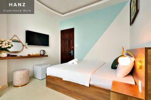 a hotel room with a bed and a tv at HANZ Vivianne Hotel in Ho Chi Minh City