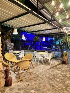eine Terrasse mit Tischen, Stühlen und Lampen in der Unterkunft Casa Emma in Rivera