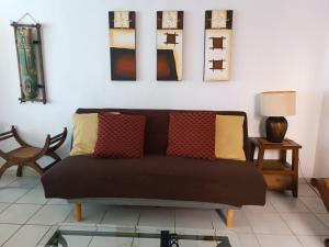 uma sala de estar com um sofá e algumas fotografias na parede em Departamento amplio y amueblado en Marina Diamante em Acapulco