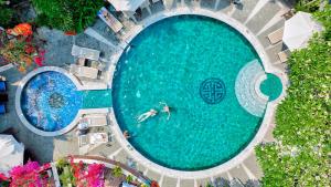 an overhead view of a person swimming in a swimming pool at Hoi An Ancient House Resort & Spa in Hoi An