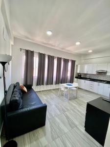 a living room with a black couch and a table at cozy apartment near the beach los corales punta Cana. in Punta Cana