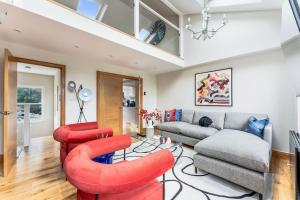 sala de estar con sillas rojas y sofá en Vibrant Urban Escape, Family Friendly - Sleeps 8!, en Londres