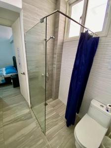 y baño con ducha de cristal y aseo. en cozy apartment near the beach los corales punta Cana., en Punta Cana