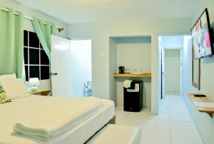 a bedroom with a white bed and a bathroom at Sands Great Bay in Treasure Beach