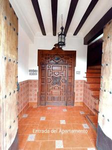 uma grande porta de madeira num quarto com piso em azulejo em El Detalle em Zahara de la Sierra