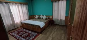 a bedroom with a bed and a blue wall at Aaren's abobe in Kulu