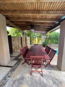 a wooden table and chairs under a wooden roof at VILLA EN MORROCOY in Tucacas
