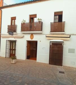 a white building with balconies on the side of it at El Detalle in Zahara de la Sierra