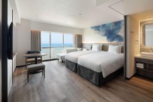 a hotel room with a large bed and a bathroom at Grand Mercure Okinawa Cape Zanpa Resort in Yomitan