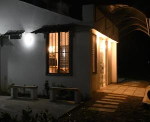 萊蒂西亞的住宿－Cruz Roja - Turismo Solimões，一座建筑,在晚上前面有两长椅