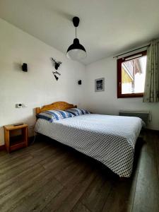 une chambre avec un lit dans une pièce avec une fenêtre dans l'établissement Résidence les Terrasses De La Bergerie (by Sabine et JeanKry), à Orcières