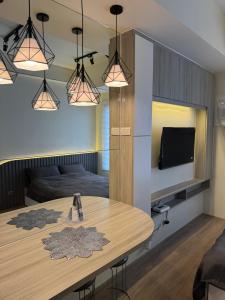a dining room with a table and a tv at Studio Unit 5 mins to IT Park with Pool, Wifi & Netflix in Cebu City