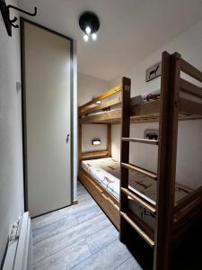 Cette chambre comprend 2 lits superposés et une porte. dans l'établissement Résidence les Terrasses De La Bergerie (by Sabine et JeanKry), à Orcières 35 autres photos