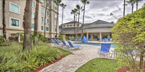 una piscina con sillas azules junto a un edificio en King Bed Studio Near Disney, en Orlando