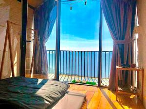 1 dormitorio con ventana grande con vistas al océano en Mây House – Sống Lưng Khủng Long, en Bắc Yên