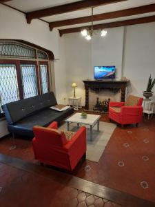 a living room with a couch and chairs and a fireplace at Casa amplia para 5 personas y cochera, a pasos del centro in La Plata