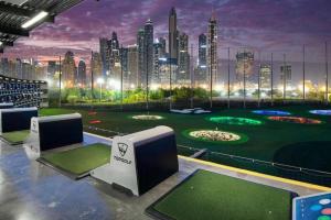 a golf course with a city skyline in the background at King Bed Condo in Dubai Sports City with Pool, Sauna, Fast Wi-Fi in Dubai