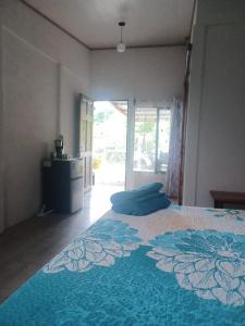 1 dormitorio con 1 cama grande con manta azul en Mangata, en Puerto Jiménez