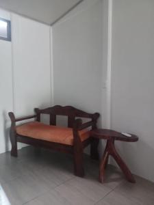 un banco de madera y un taburete en una habitación en Mangata, en Puerto Jiménez