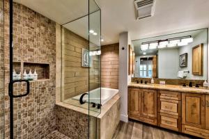 a bathroom with a glass shower and a tub at Lakeland Village 620 - Beachfront Bliss in South Lake Tahoe +26 photos