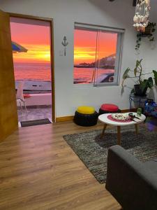 een woonkamer met uitzicht op de zonsondergang over de oceaan bij BAHÍA SUR HOUSE - San Bartolo in San Bartolo
