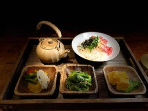 a tray with four dishes of food and a tea pot at 本氣宿泊Honkiya in Hengchun