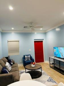sala de estar con sofá y TV en Ruby’s Place, en Nassau