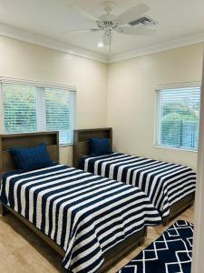 twee bedden in een kamer met twee ramen bij Ruby’s Place in Nassau