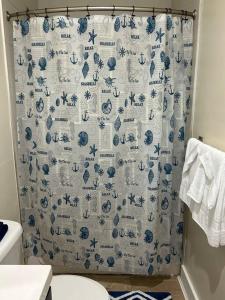 baño con cortina de ducha azul y blanco en Ruby’s Place, en Nassau